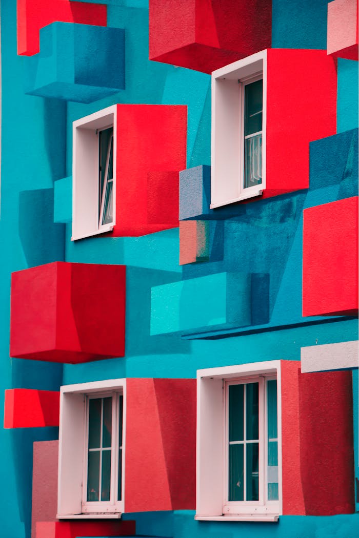 Vibrant and colorful geometric facade featuring red and blue cubes with windows.